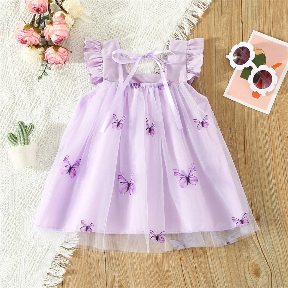 Front view of girls' sleeveless butterfly mesh summer dress with bow