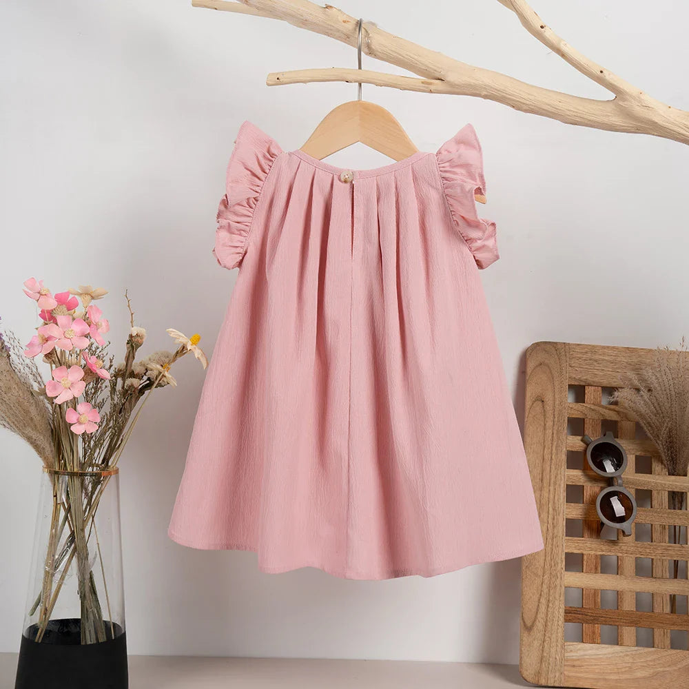 Detail of neckline and sweet flying sleeves on a pink girls' summer dress for kids