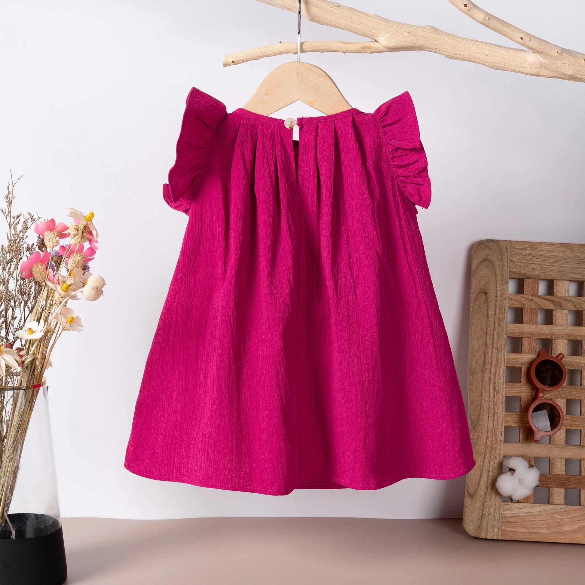 Close-up of flying sleeves on a pink girls' casual summer dress, polyester fabric