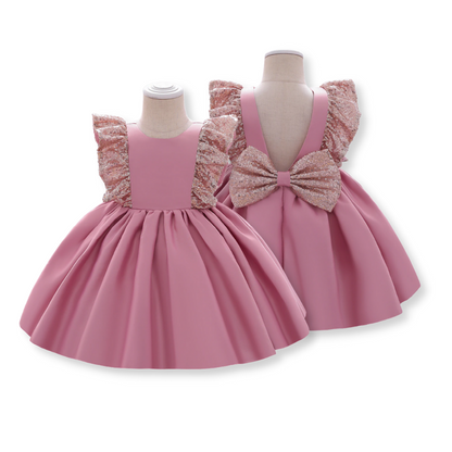 Close-up of sequin bow detail on a girls' Christmas plaid dress, festive baby girl outfit
