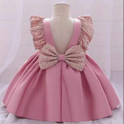 Sparkling sequin bow and vibrant plaid on a girls' Christmas dress, charming toddler fashion