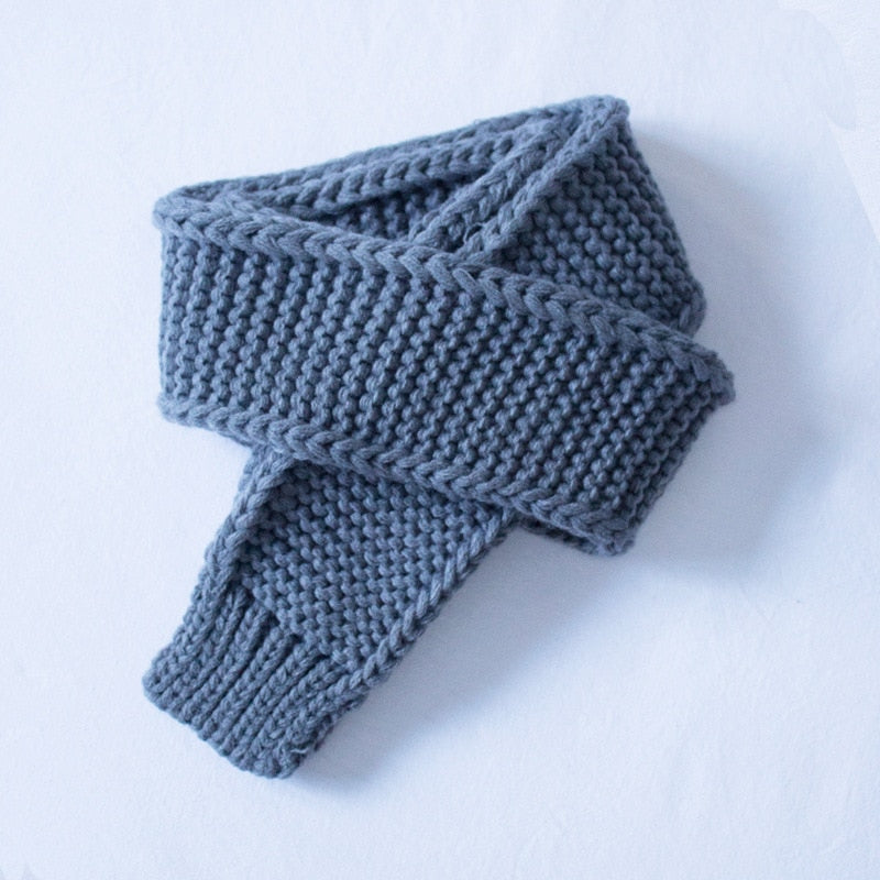 Textured image of a gray knitted infinity scarf, a versatile children's accessory