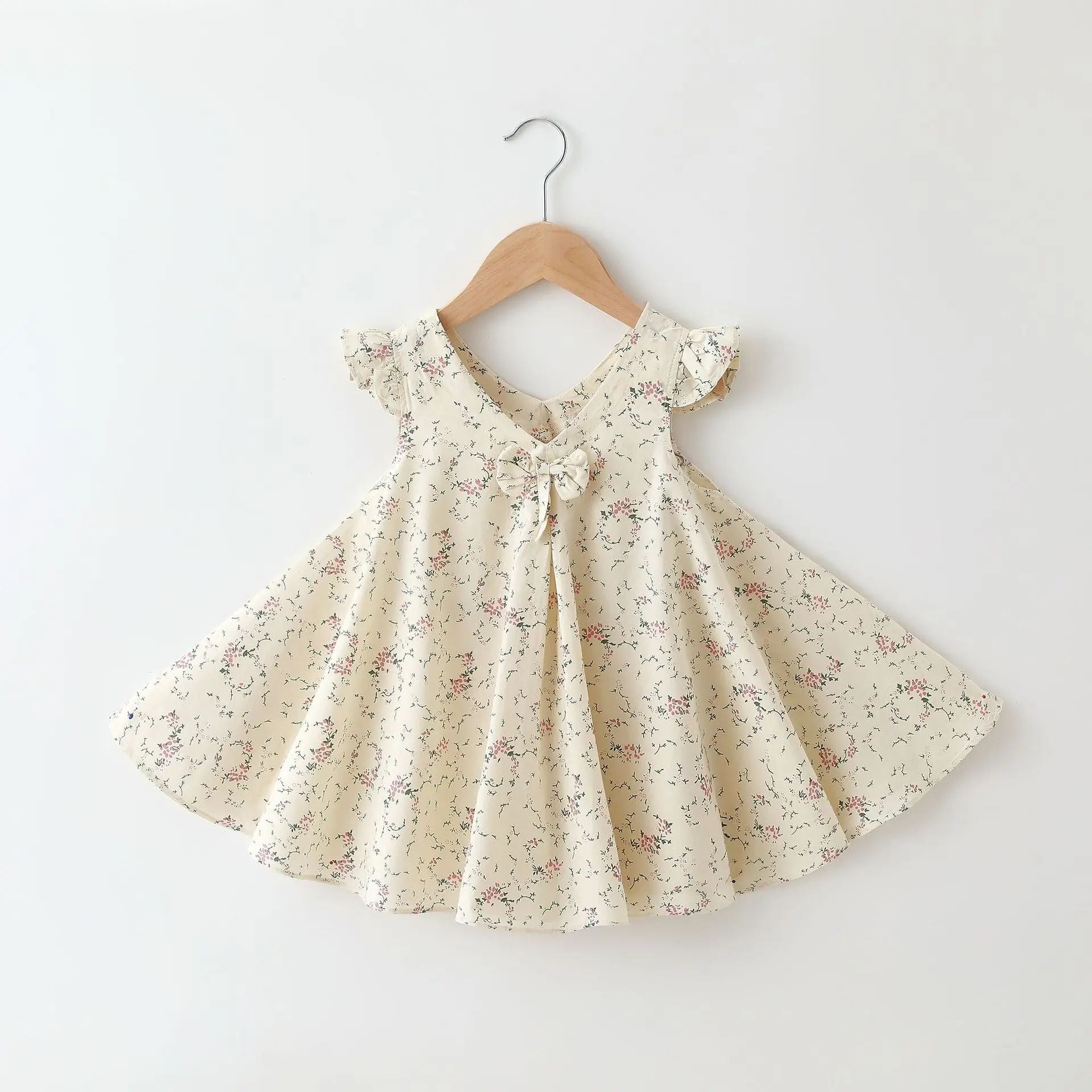 Detail of the soft cotton fabric and floral pattern on a girls' A-line summer dress.