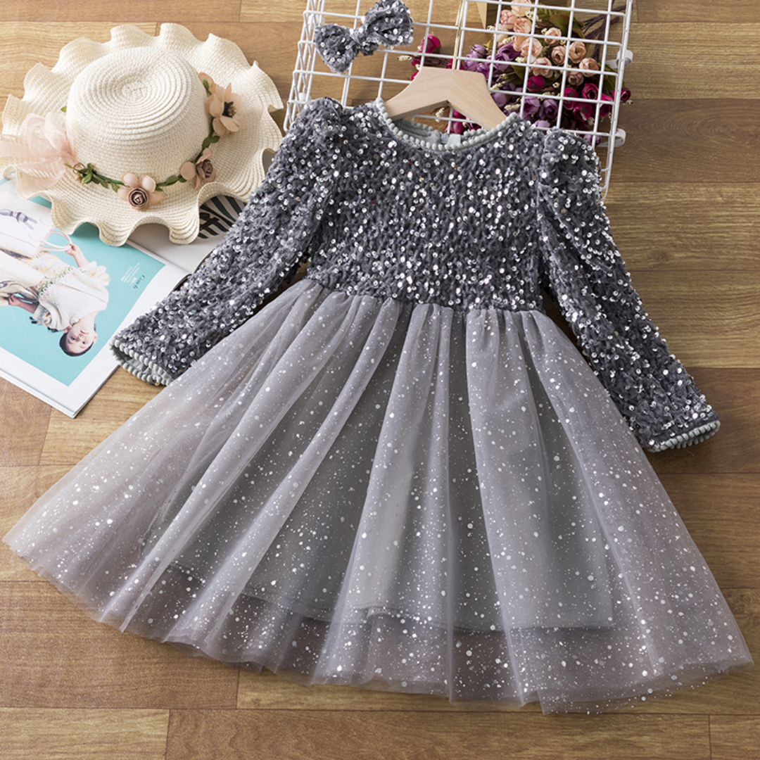 Close-up of a girl's sequin bodice on a long sleeve princess party dress, showcasing intricate detail.