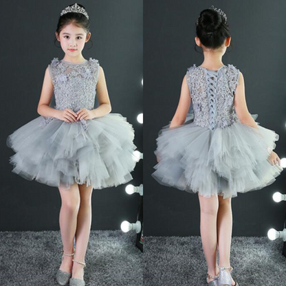 Close-up of a girl's white lace applique and rhinestone detail on a sleeveless tulle prom dress