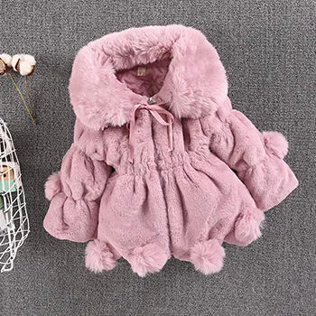 Side profile of a young girl wearing a white faux fur winter princess jacket, warm & fashionable