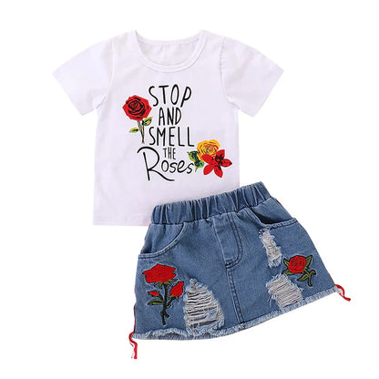 Cute toddler girl in a floral embroidered pullover and practical matching skirt set