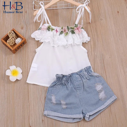 Toddler girl in a white floral halter top and blue denim shorts, cute kids summer fashion