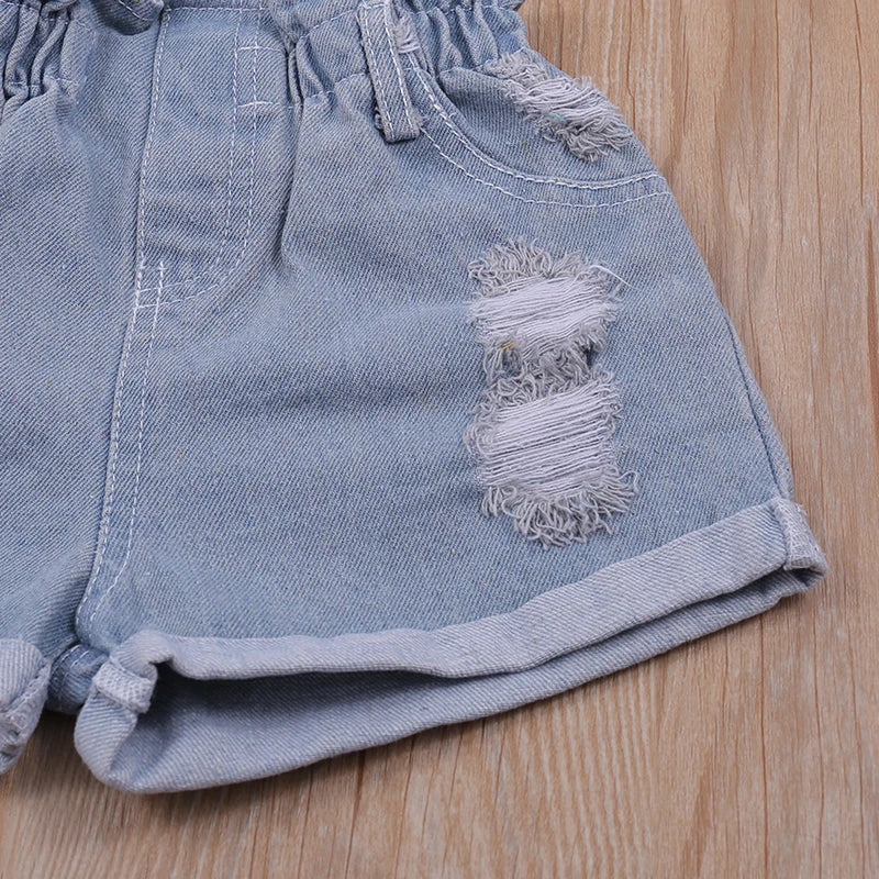 Kids summer fashion: girl's floral halter top with matching denim shorts on a flat lay