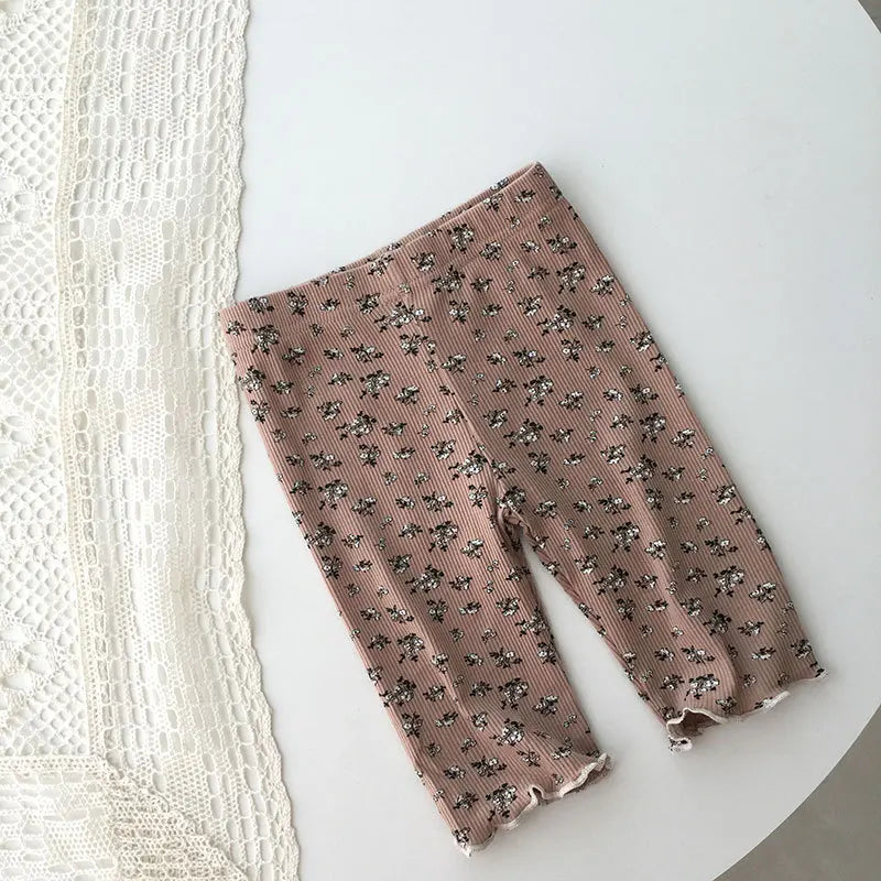 Toddler girl wearing pink floral pajama shorts set, smiling, cute children's sleepwear
