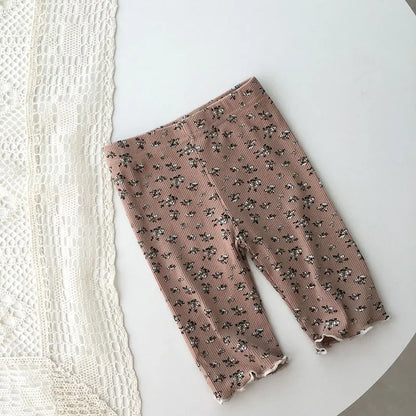 Toddler girl wearing pink floral pajama shorts set, smiling, cute children's sleepwear