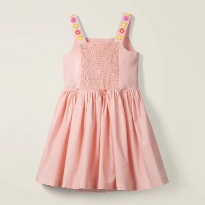 Toddler girl wearing a breezy floral beach dress, perfect for summer play