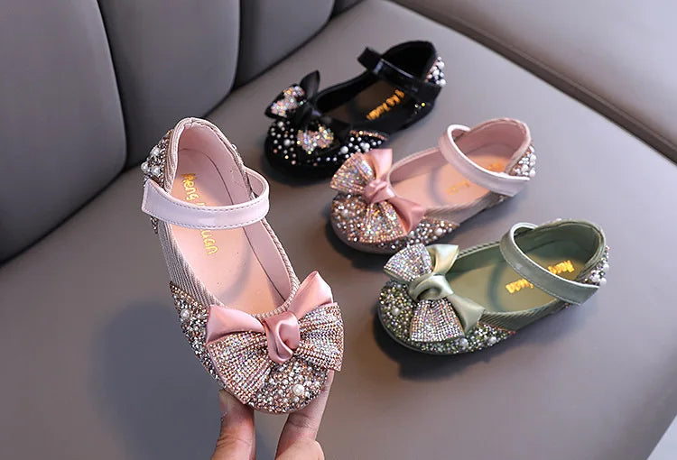 Girls' stylish pink princess shoes with a prominent rhinestone bow, fashion-forward kids' footwear