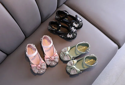 Pair of girls' pink special occasion shoes with a glamorous rhinestone bow design