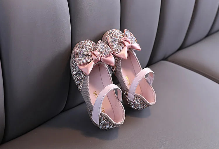 Detailed shot of girls' pink party flats showcasing the quality and rhinestone bow embellishment