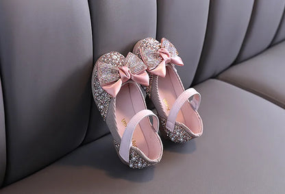 Detailed shot of girls' pink party flats showcasing the quality and rhinestone bow embellishment