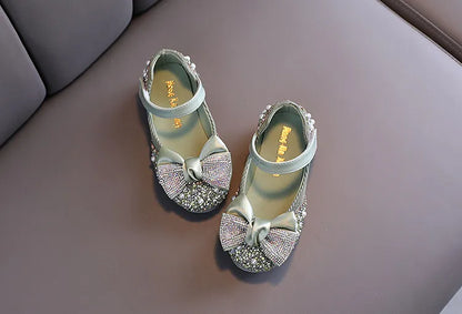 Girls' pink party flats featuring a large, intricate rhinestone bow, perfect for a grand entrance