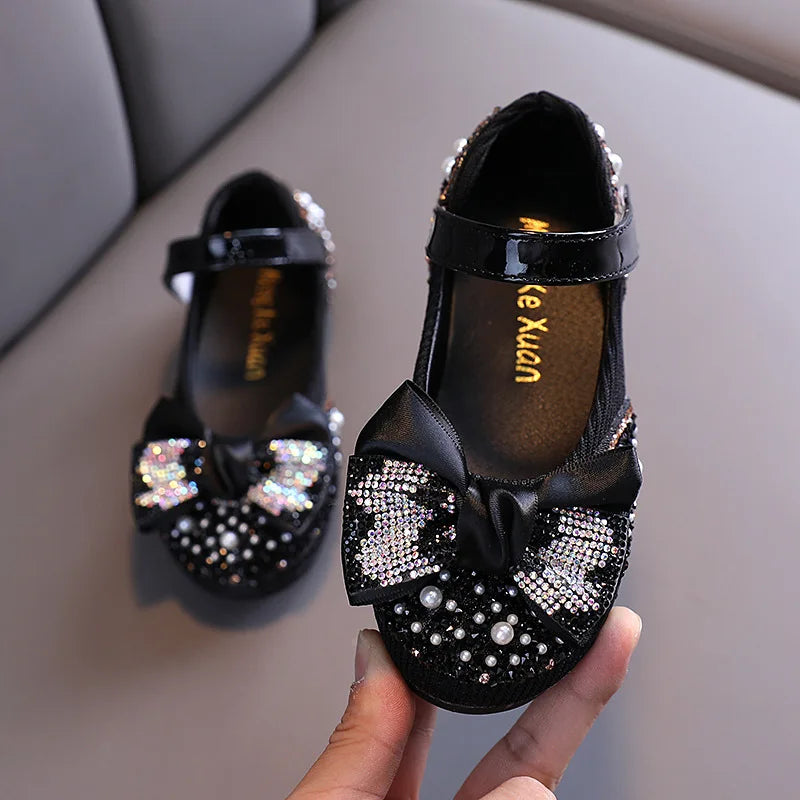 Pair of girls' sparkling pink princess flats with delicate rhinestone bow detail, dress shoes