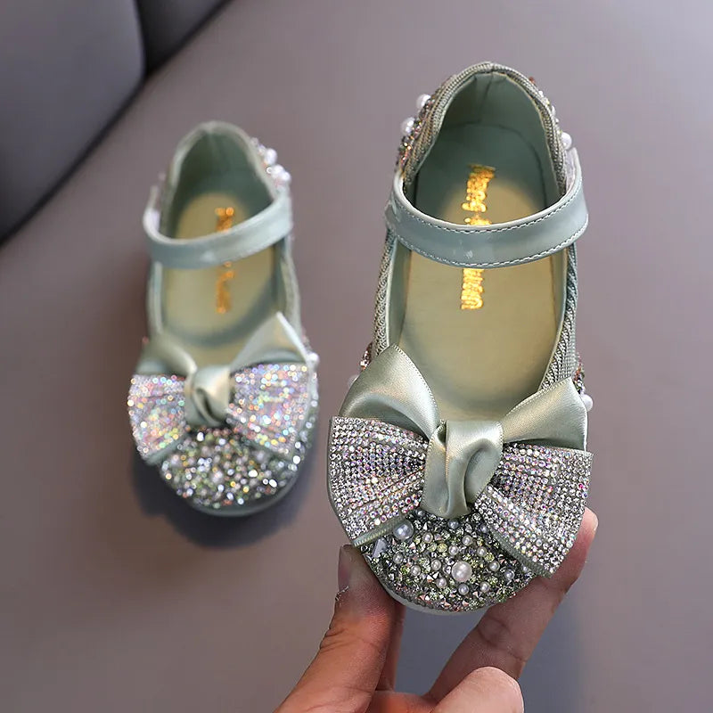 Back view of girls' pink dress shoes with a subtle rhinestone bow, ideal for formal events