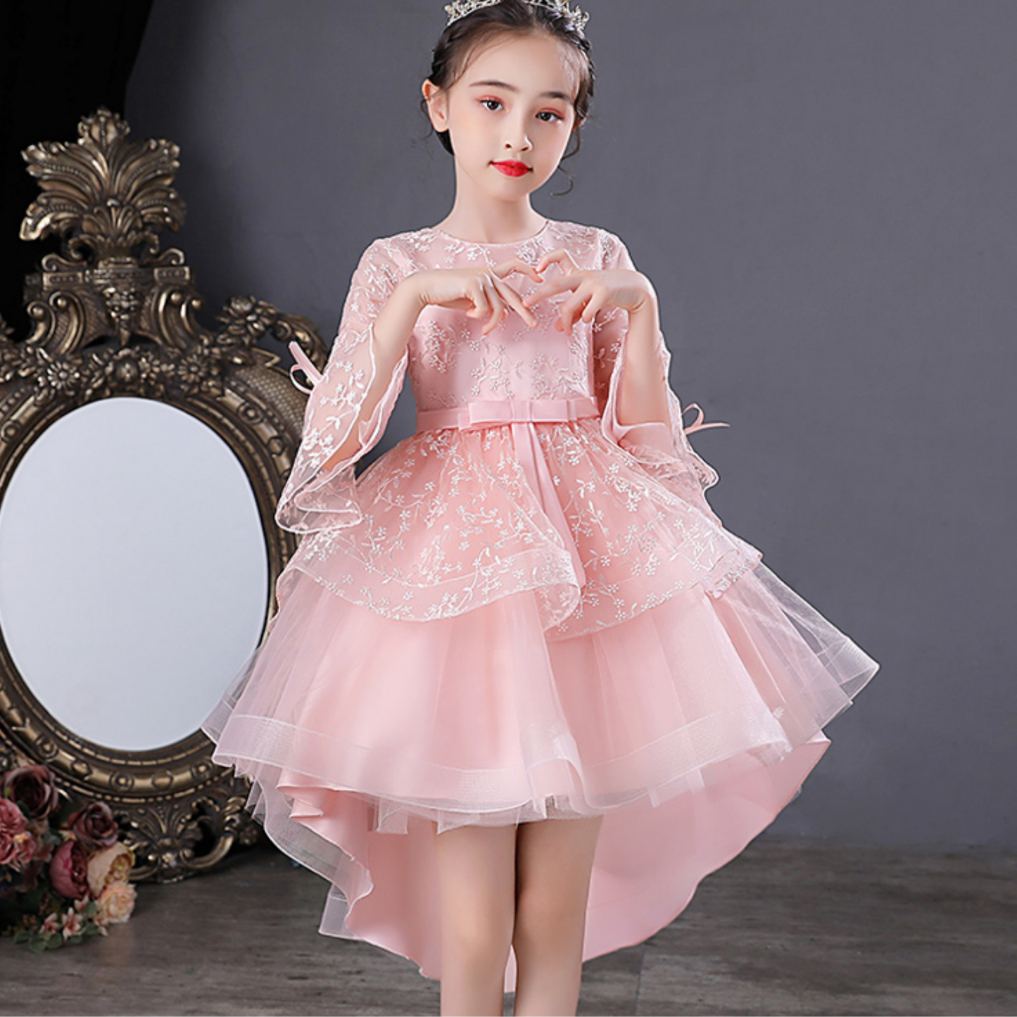 Closeup of girls' princess party dress with intricate jacquard fabric and delicate mesh bow.