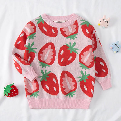 Close-up of the buttons and pear fruit pattern on a pink girls' knitted cotton sweater, soft and warm.