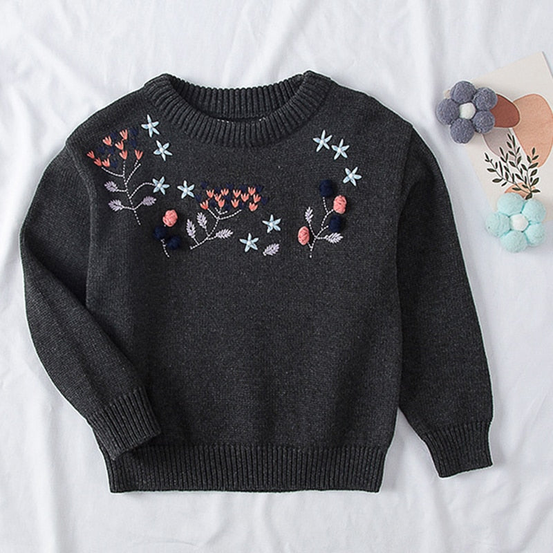 Close-up of a pink girls' cotton knitted sweater featuring a cute pear fruit pattern, ideal for baby clothing.