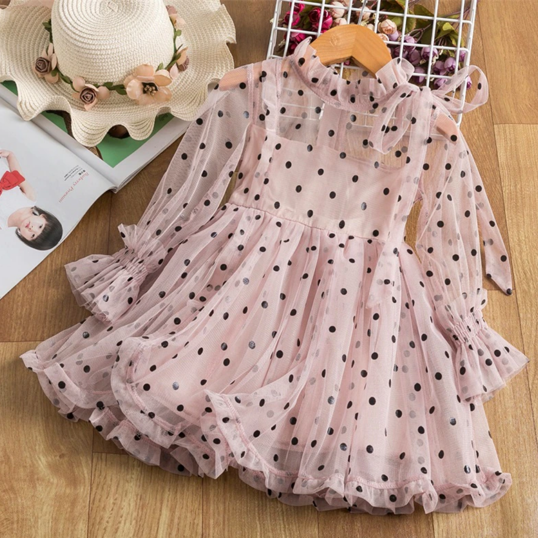 Close-up of dotted mesh fabric on a girls' long sleeve ruffle dress, children's clothing detail