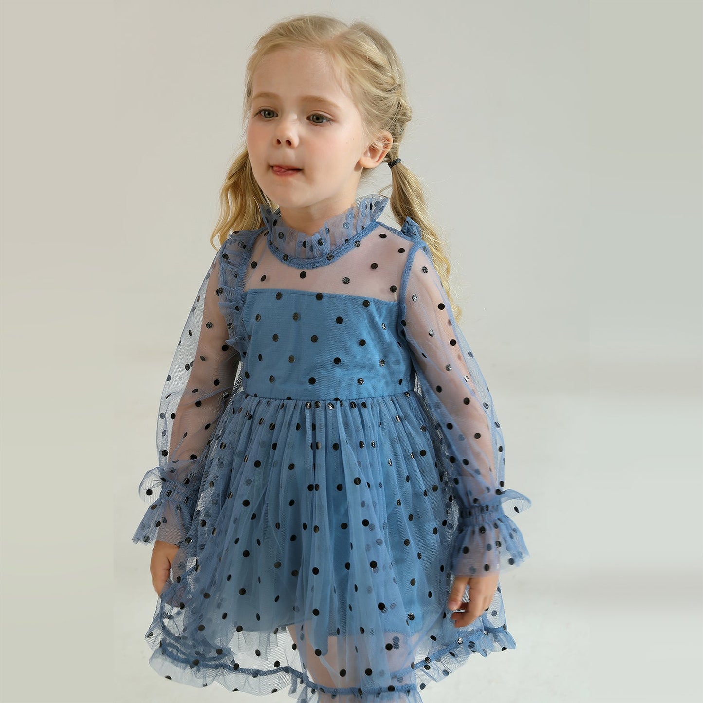 Flat lay of a girls' long sleeve dotted mesh ruffle dress, showcasing the design and fabric
