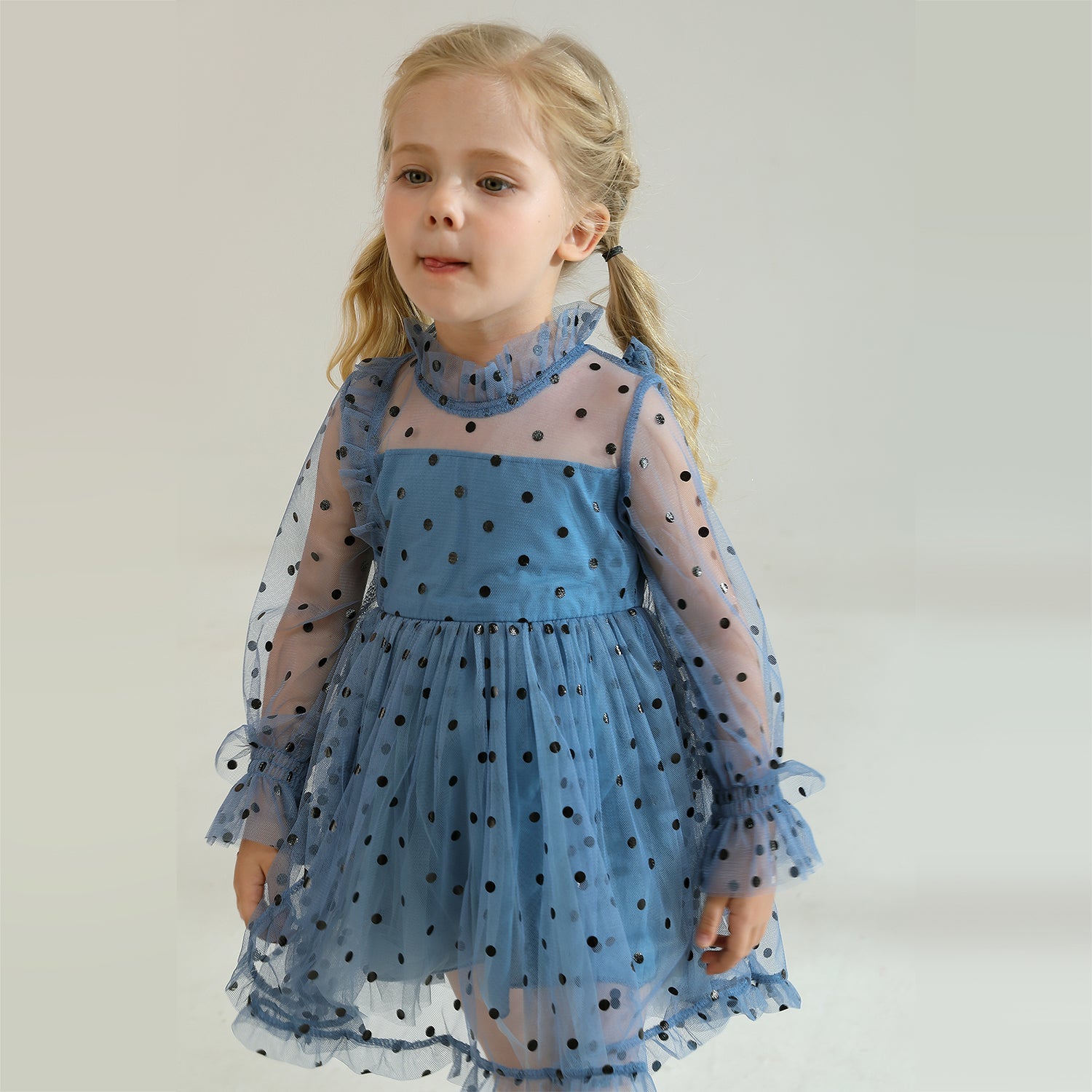 Flat lay of a girls' long sleeve dotted mesh ruffle dress, showcasing the design and fabric