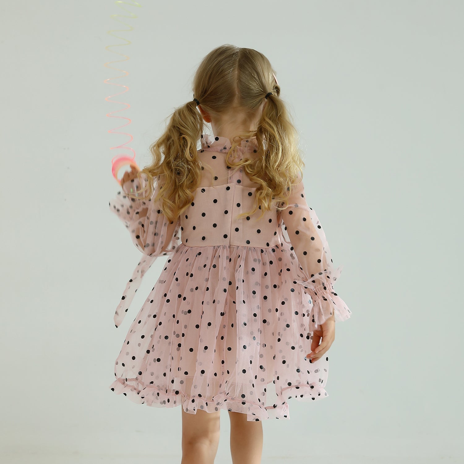 Back view of long sleeve dotted mesh ruffled dress for girls, with keyhole detail.