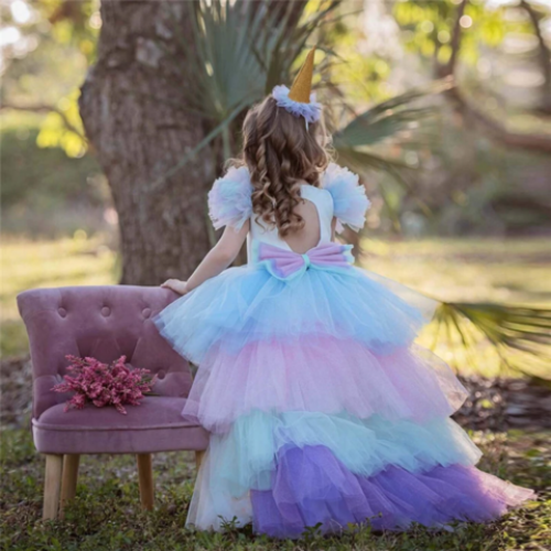 Toddler girl wearing a vibrant unicorn princess dress with sheer wings & fluffy long back skirt