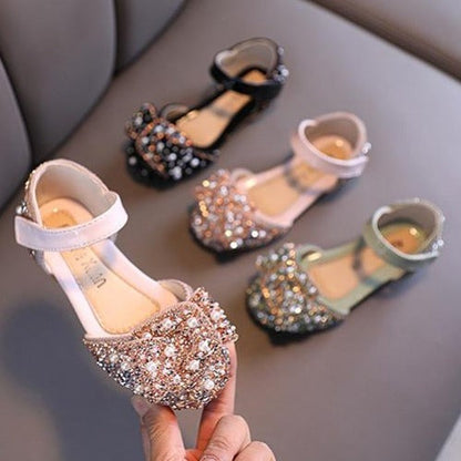 Pink open side kids' sandals featuring pearl and rhinestone embellishments, ideal girl's party shoes