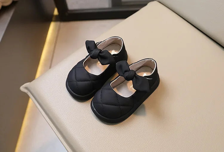 Girls' comfort shoes: A foot wearing pink bowknot leather Mary Janes, ideal for toddlers