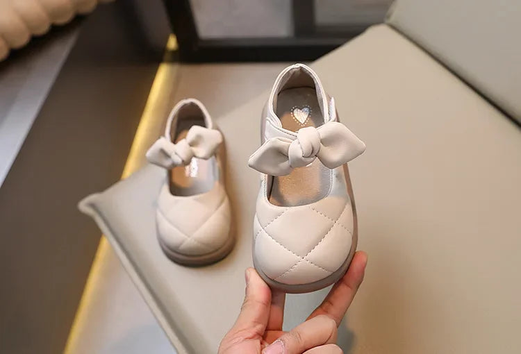 Overhead shot of pink bowknot Mary Janes, emphasizing the soft texture and bow detail