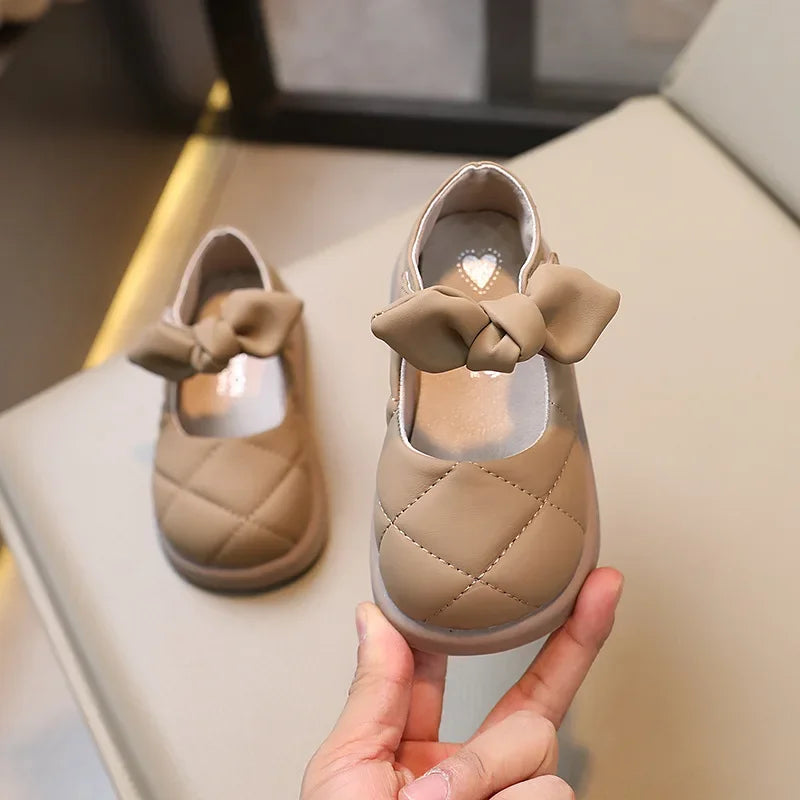 Detail of the hook-loop strap on girls' pink bowknot Mary Janes, ensuring a secure fit for toddlers