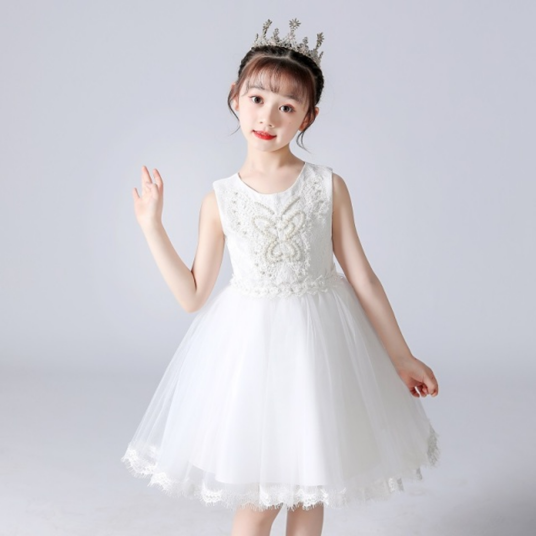 Close-up of pearl and rhinestone details on a girls lace princess party dress with butterfly accents.