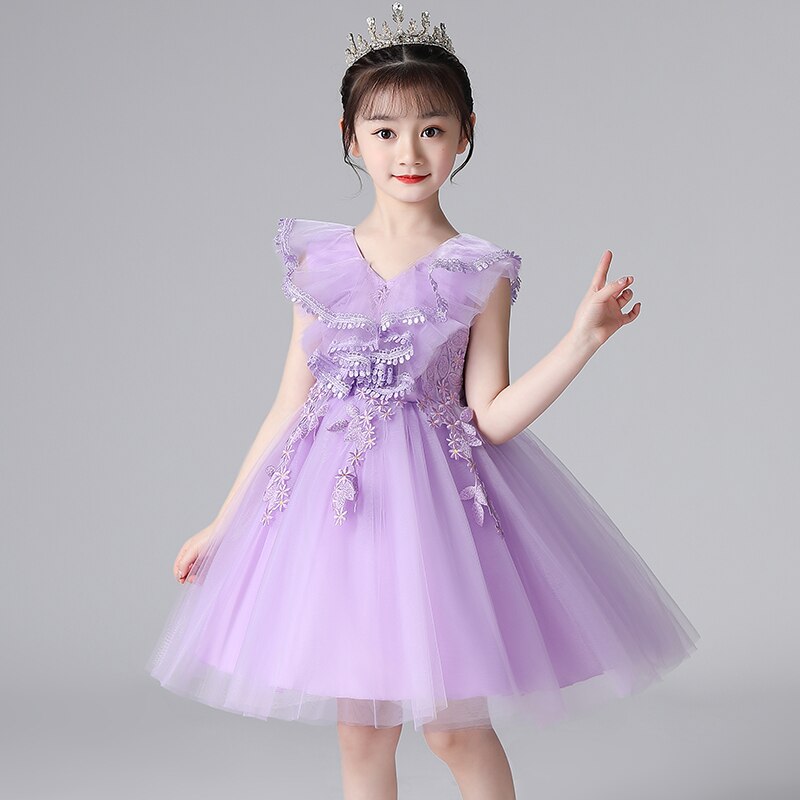 Detailed shot of delicate lace and butterfly embroidery on a girls pink princess party dress.