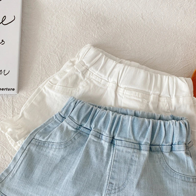 Girls' patterned cotton ruffle shorts with small dots, a fun summer fashion choice.