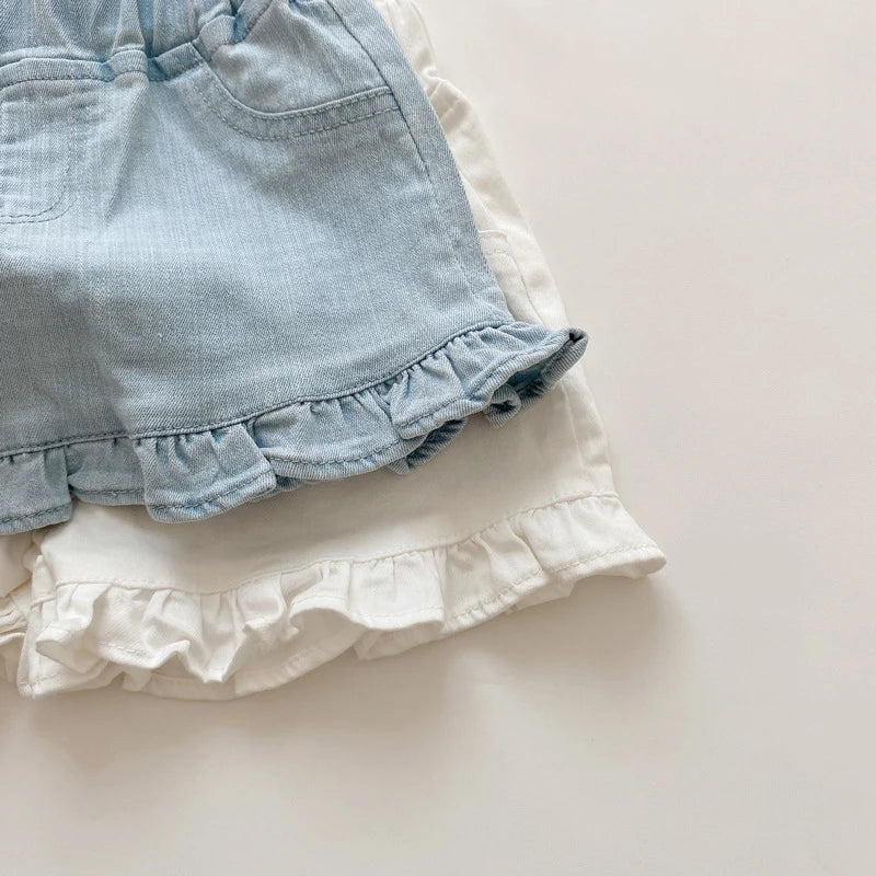 Detail of the elastic waistband on girls' cotton ruffle shorts, ensuring a snug fit.