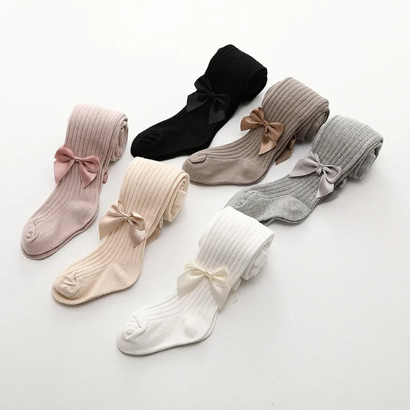 Display of girls' assorted cotton bow socks against a plain background, focus on quality