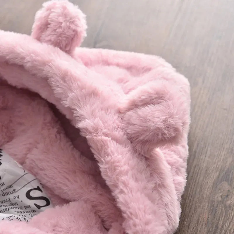 Girl smiling in a warm pink winter coat, faux fur hood framing her face