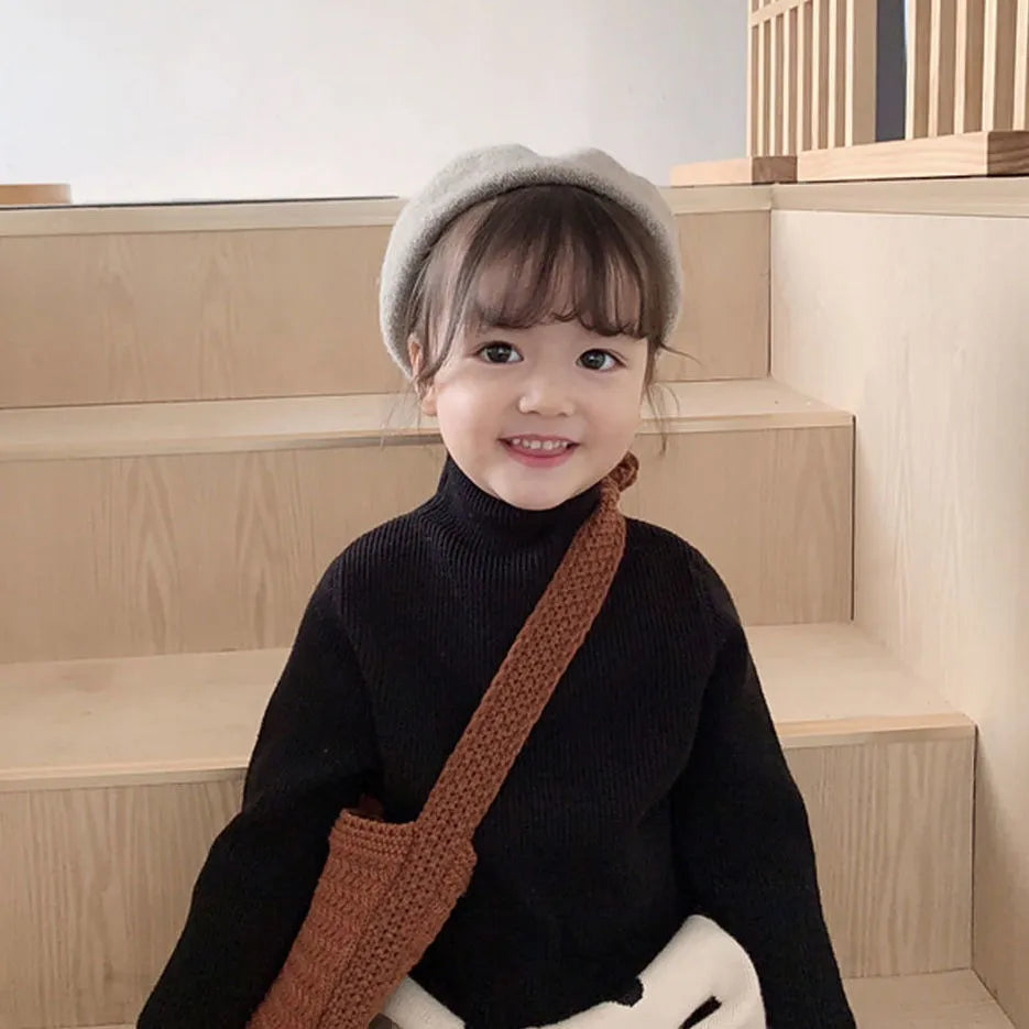 Toddler girl wearing a blue knitted turtleneck sweater, comfortable and warm winter kids apparel
