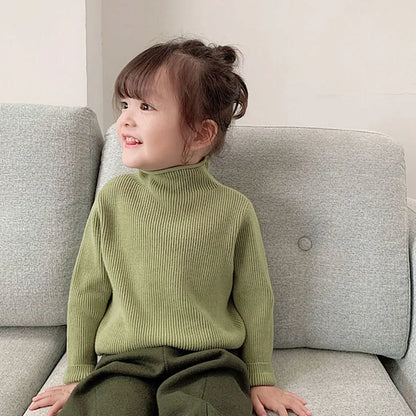 Infant girl in a white knitted turtleneck pullover, soft and warm cotton blend winter wear