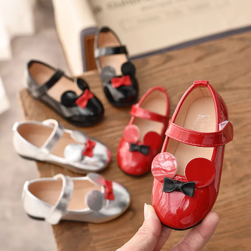 Close-up of a girl's soft patent leather flat shoe, featuring hook and loop strap and anti-slip sole