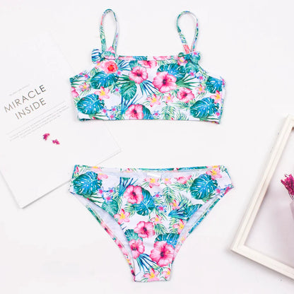 Set of three girls' print bikini options: polka dot, flamingo, and floral with bow details