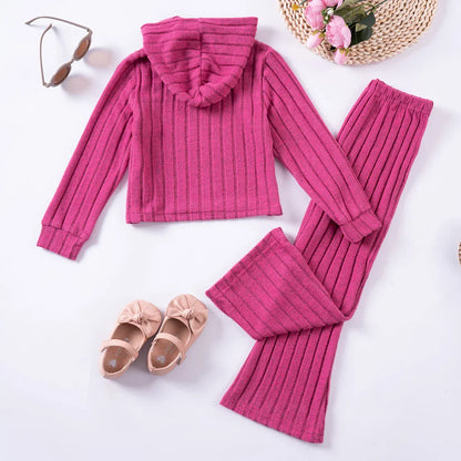 Toddler girl smiling in a comfy pink tracksuit, ideal kids fashion cozy winter outfit.