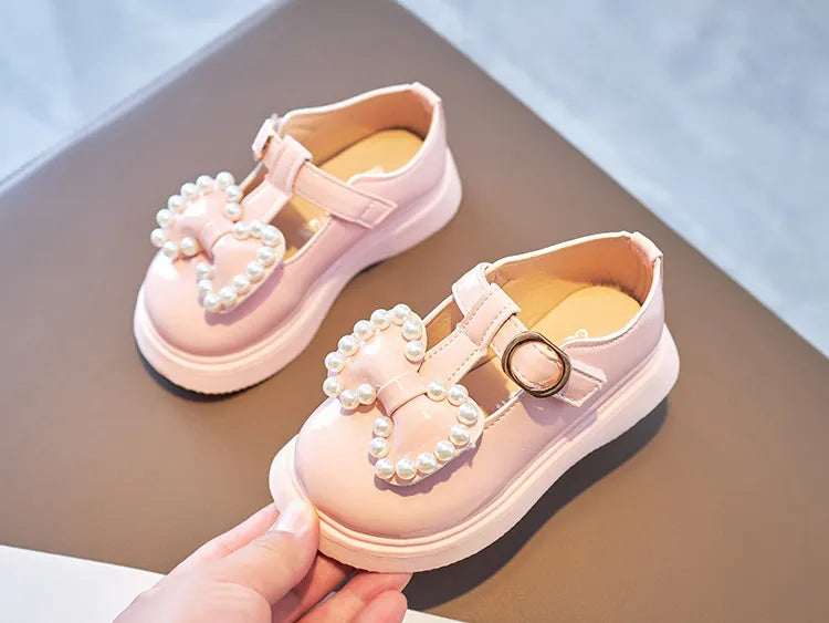 Girls footwear: pink princess flats with a decorative bow-knot and pearls, great for parties.
