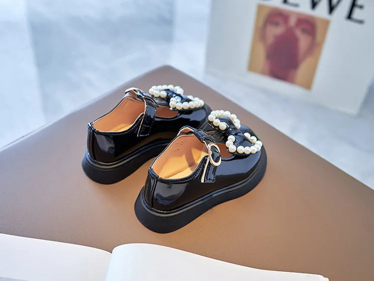 Pink girls ballet flats with a front bow-knot and pearl details, essential kids fashion.