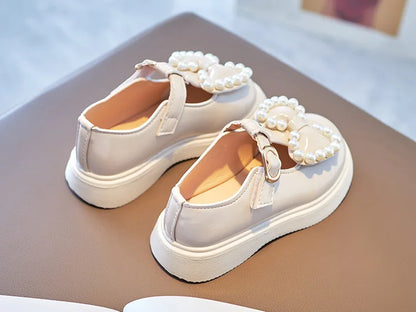 A pair of adorable girls pink princess flats, featuring a lovely bow-knot and elegant pearl accents.