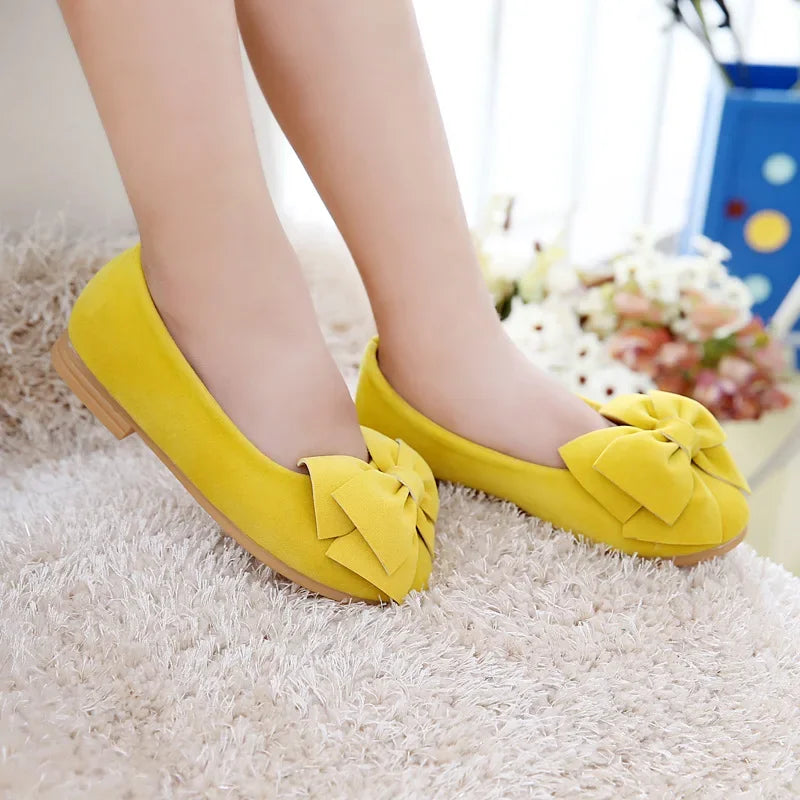 Childrens' blue flat slip-on sandals with a charming bowtie design, ideal for holidays